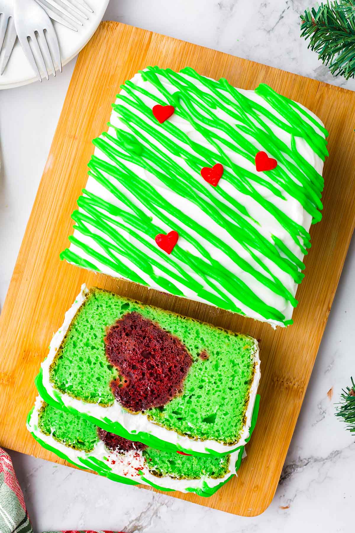 2 slices of grinch cake on a wood cutting board.