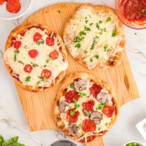 3 variations of Naan Bread Pizza on a cutting board.