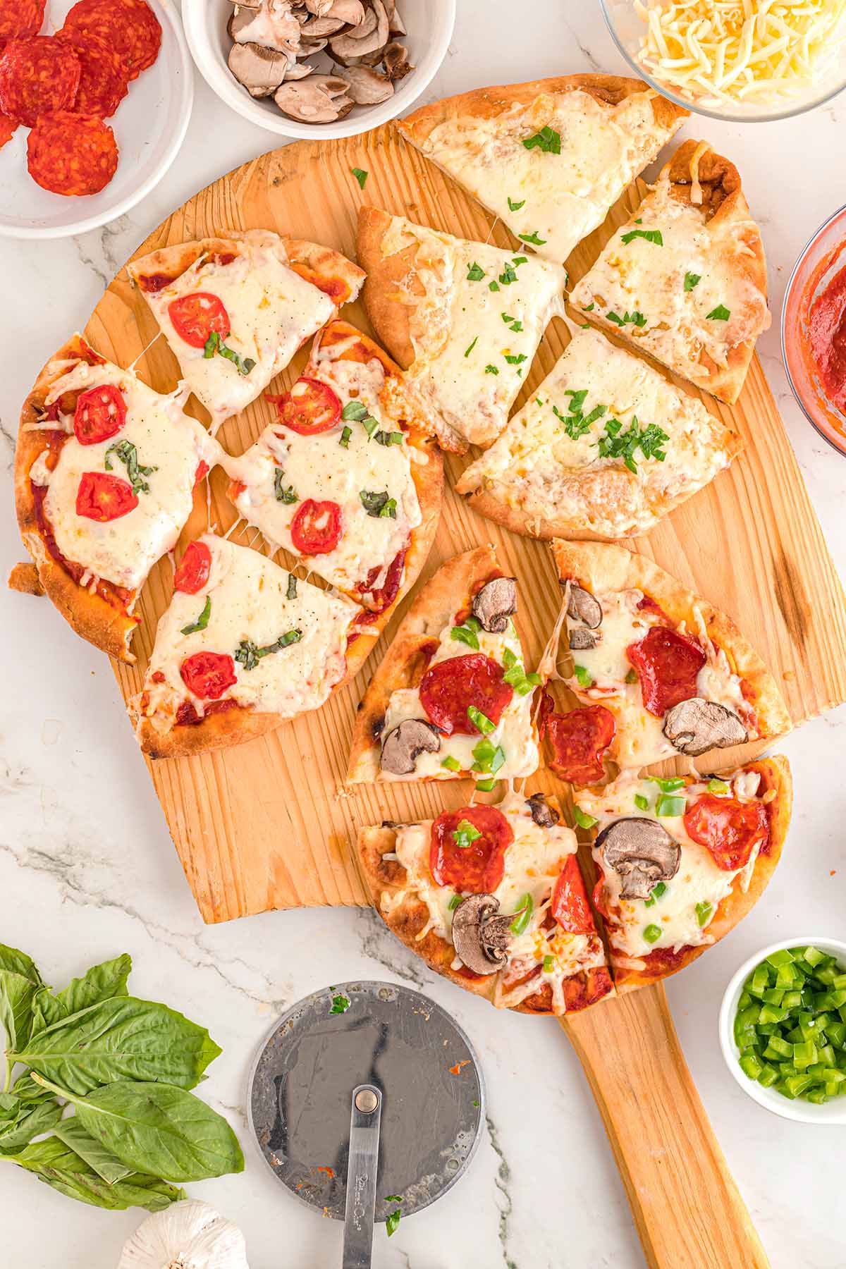 3 Naan Bread Pizza with different toppings cut into slices.