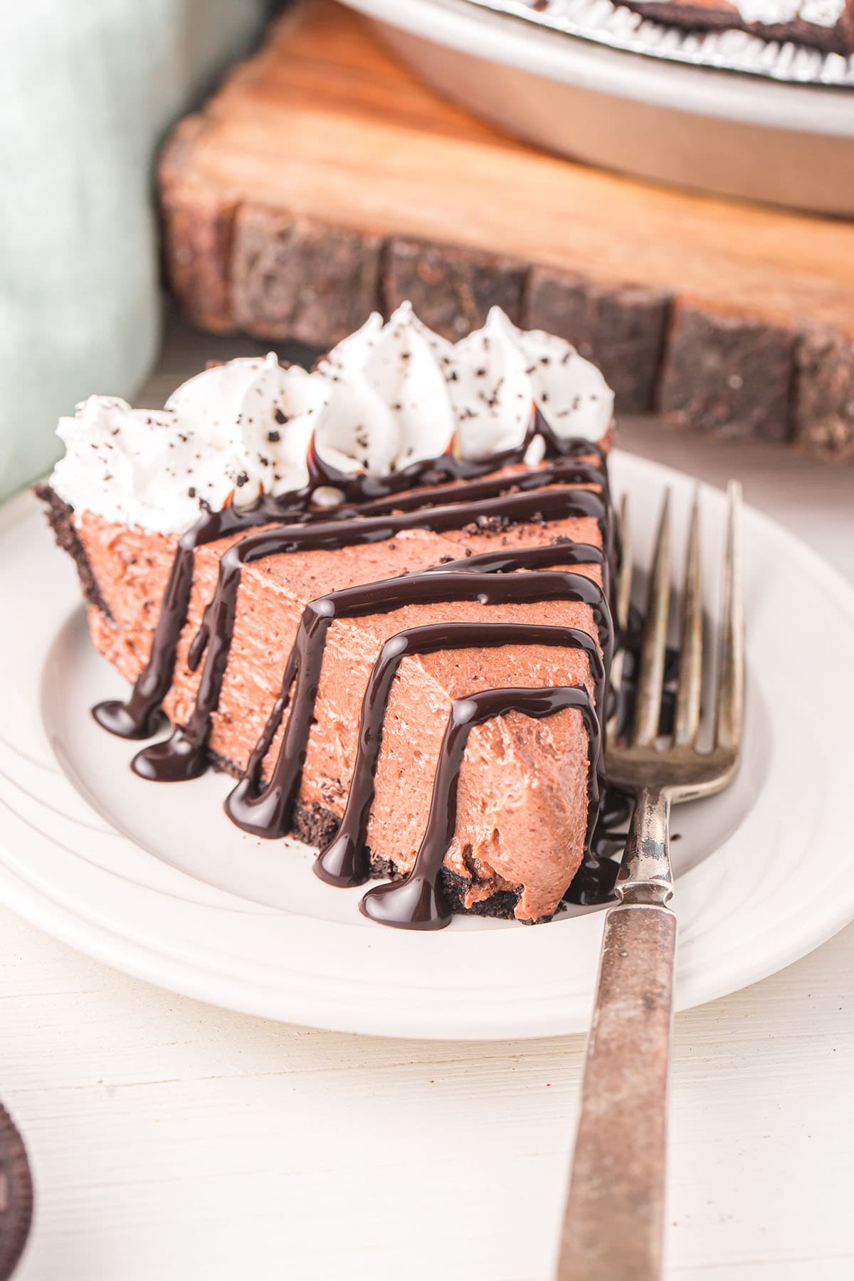 Nutella Pie on a plate with chocolate drizzle and whipped cream on top.