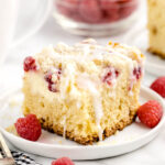 Raspberry Coffee Cake on a white plate with white chocolate drizzle.