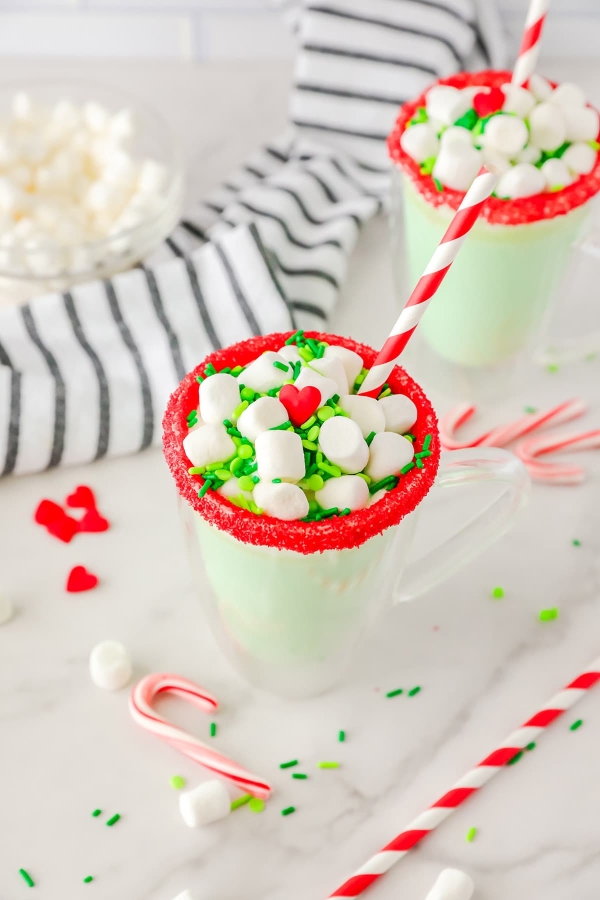 Slow Cooker Grinch Hot Chocolate topped with marshmallows and green sprinkles.