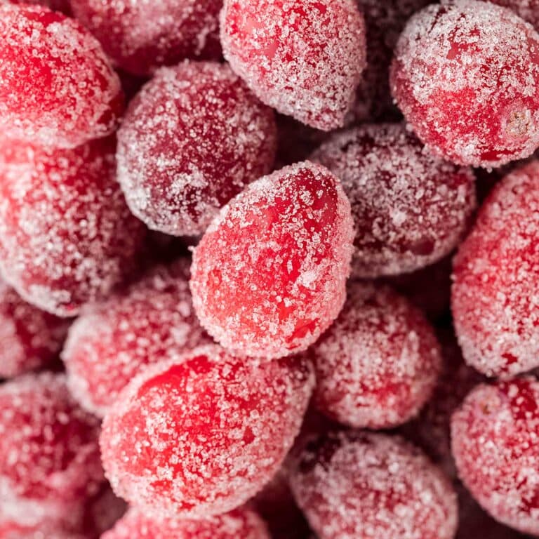 a couple of sugar coated cranberries in a bowl.