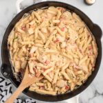 Cajun Chicken Pasta in a skillet on a white table.
