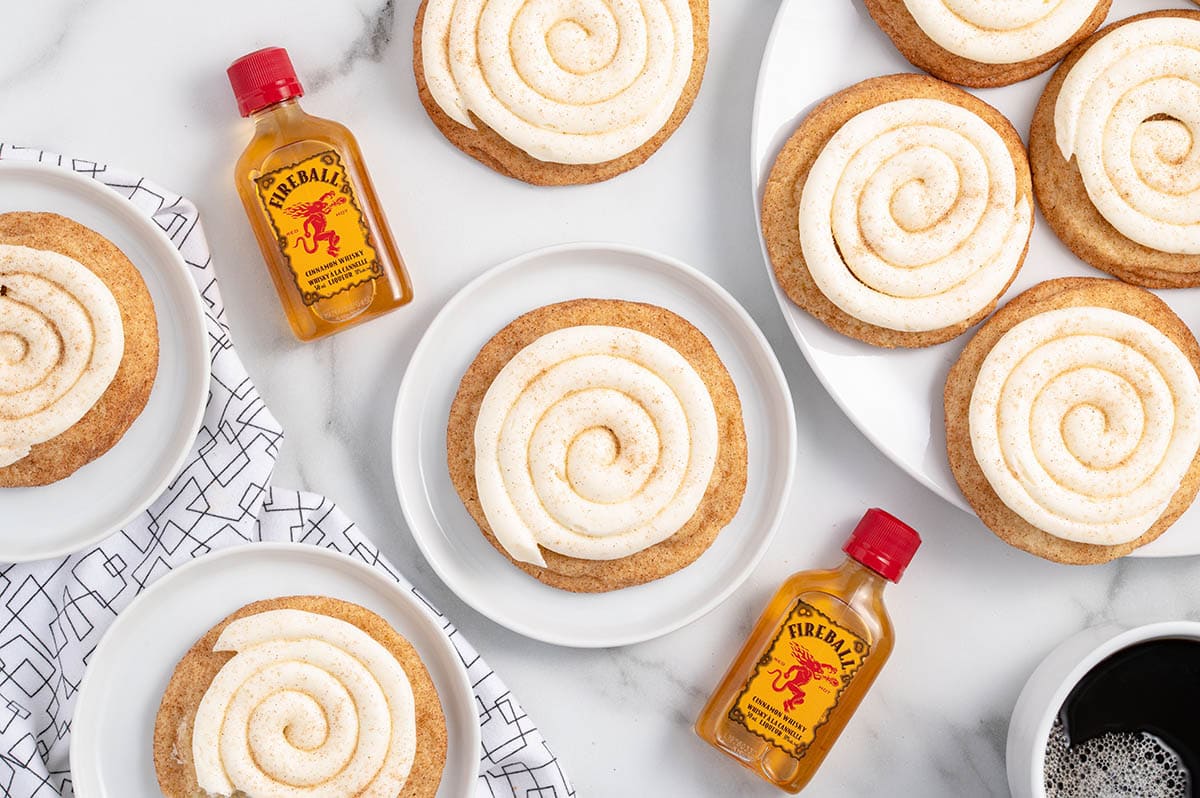 a couple of Fireball Cookies on a white table and 2 bottles of fireball cinnamon whisky on the background.