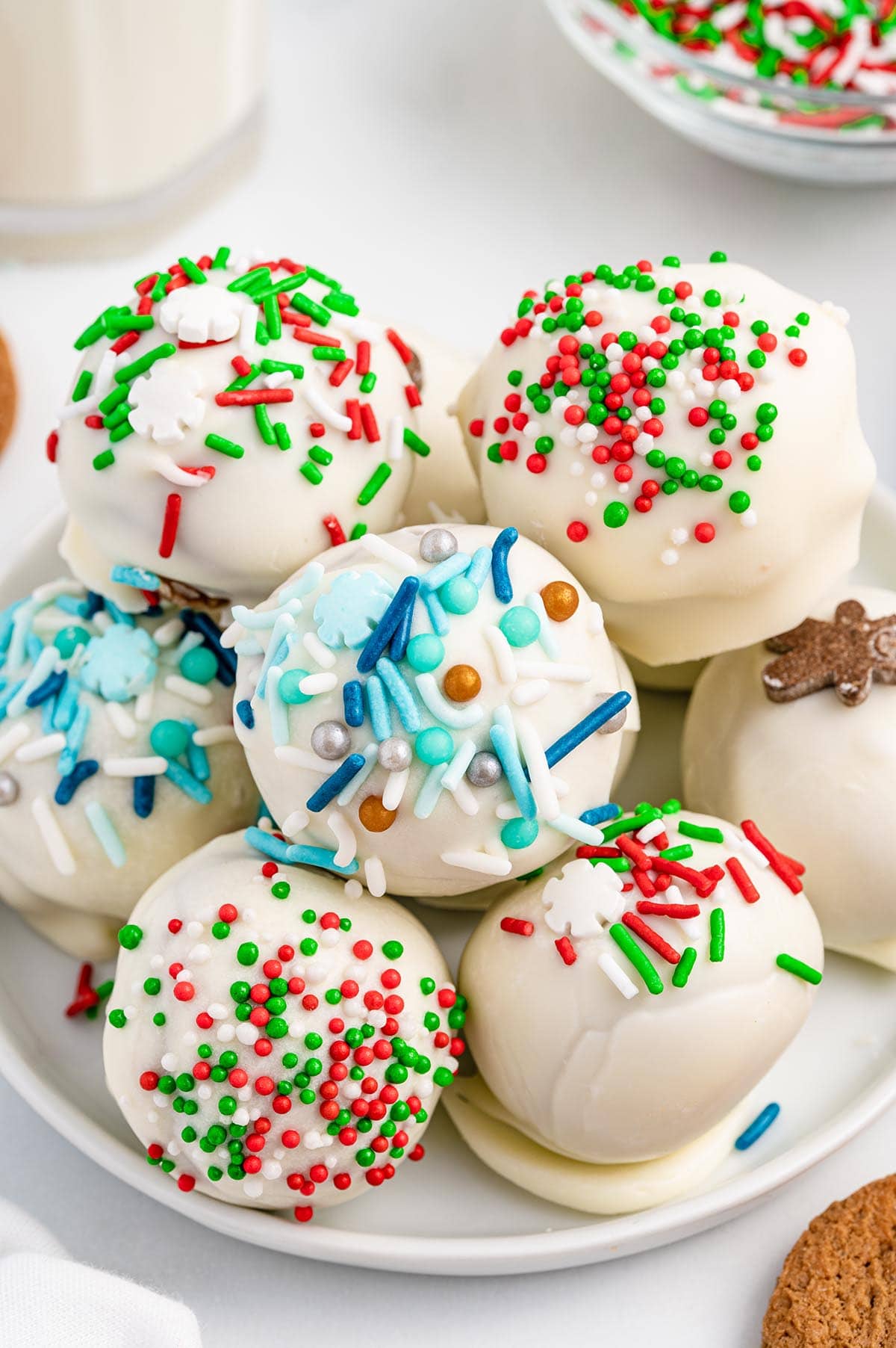 Gingerbread Truffles with holiday sprinkle stacked on top of white plate.