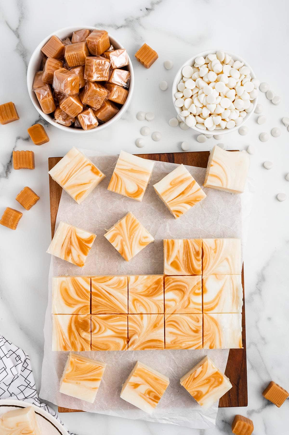 White Chocolate Caramel Fudge cut into squares on top of cutting board.