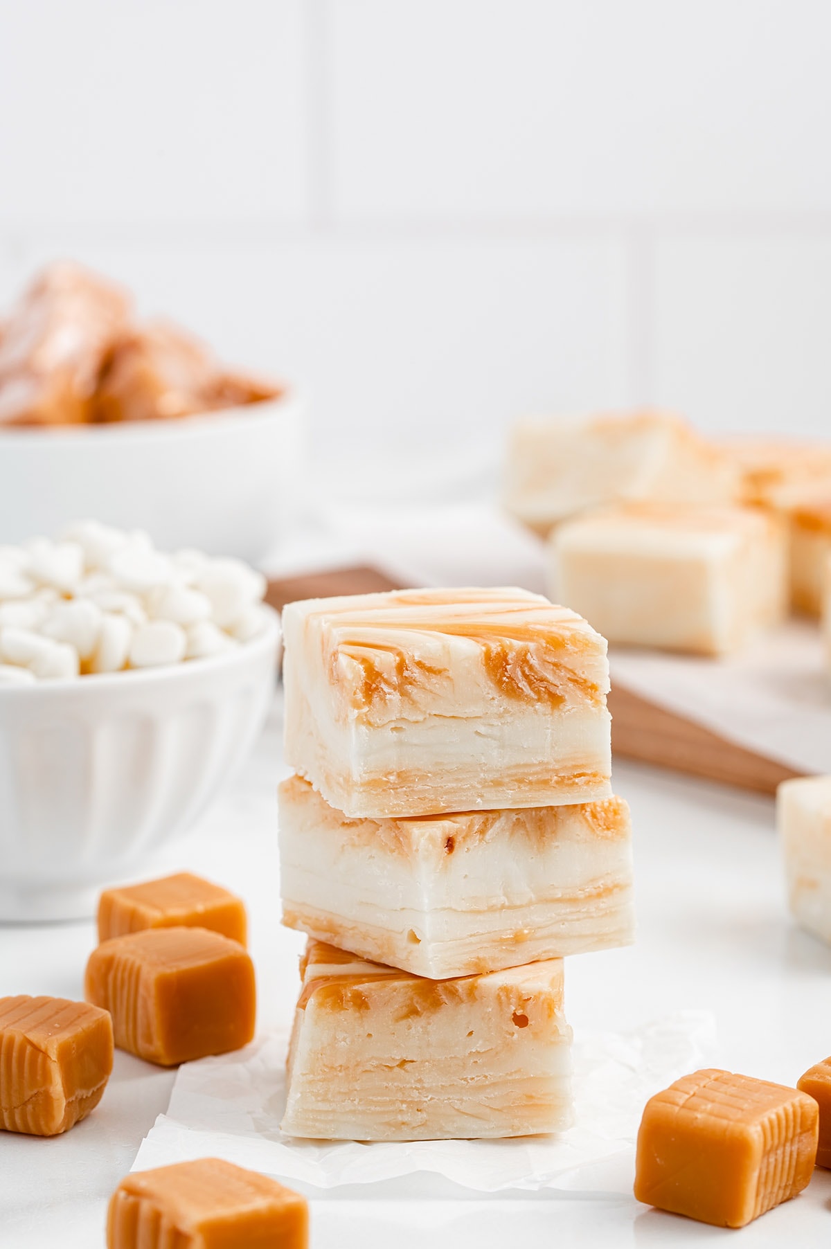 a square piece of White Chocolate Caramel Fudge stacked on a white table.