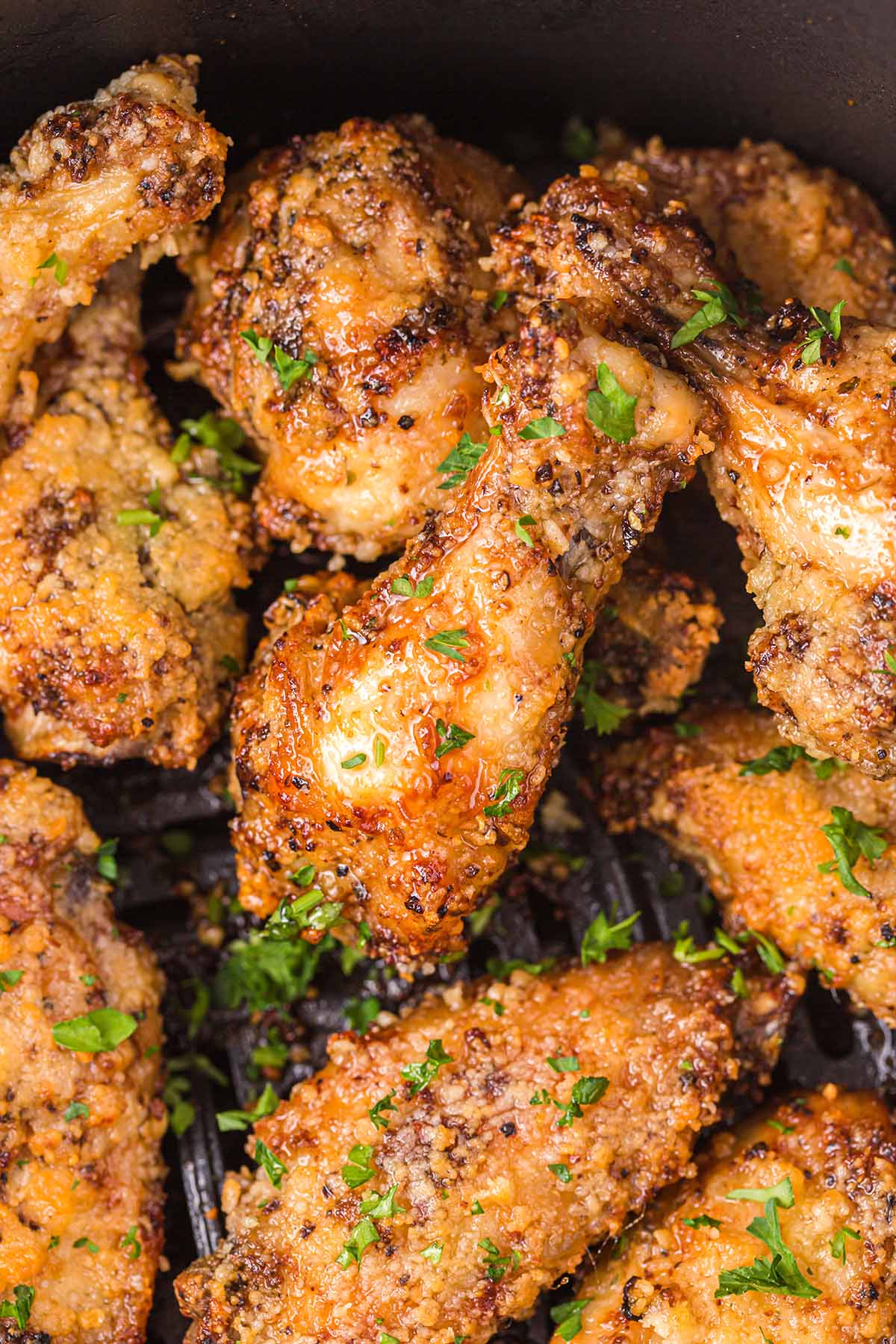 Air Fryer Parmesan Garlic Chicken Wings garnished with parsley and parmesan cheese.