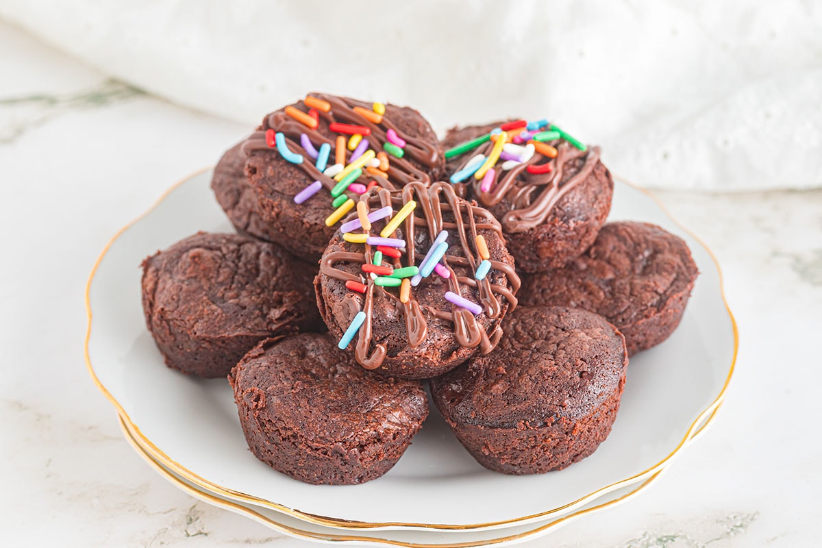 a couple of Brownie Bites on a plate with toppings.