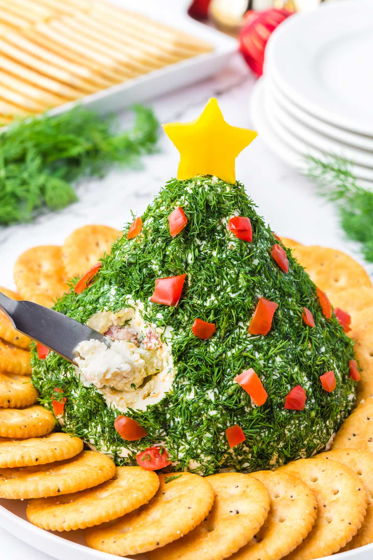 Christmas Tree Cheese Ball with crackers on a plate.