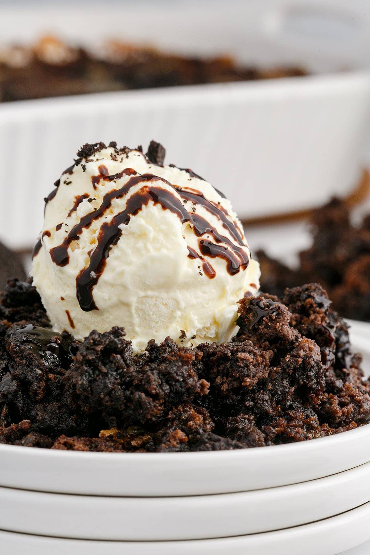 Oreo Dump Cake with ice cream and drizzled chocolate sauce on top.