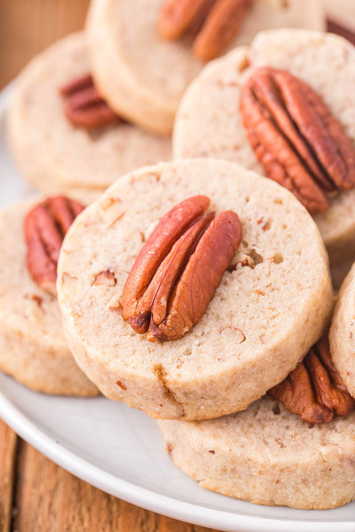 a couple of Pecan Sandies stacked on a white plate.