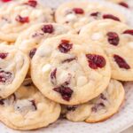 a couple of White Chocolate Cranberry Cookies on a white plate.