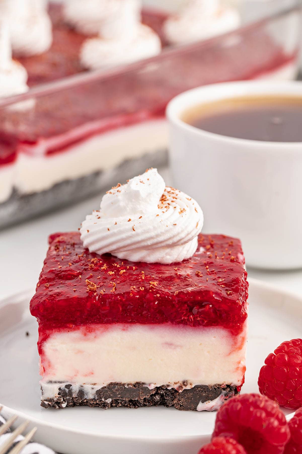 a slice of Chocolate Raspberry Cheesecake Delight on a white plate.