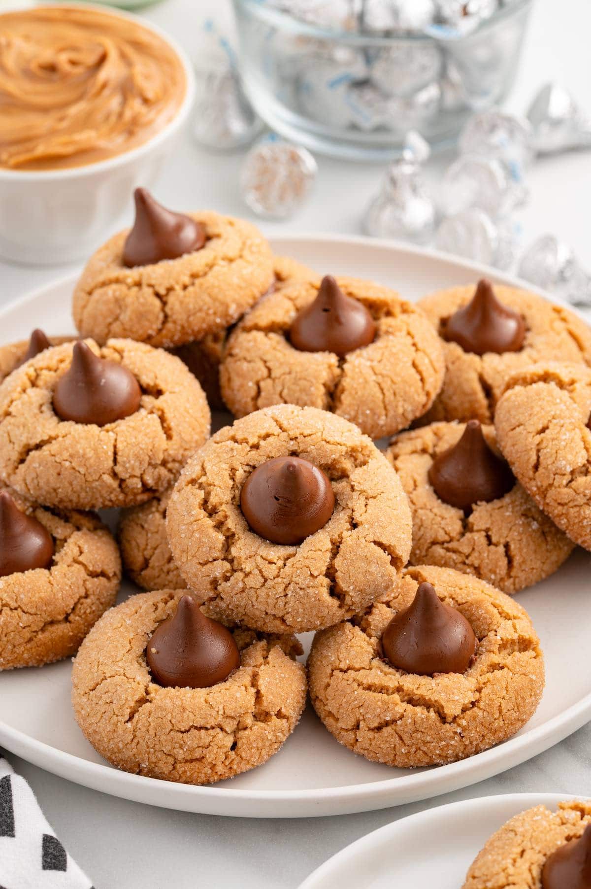 a couple of peanut butter kiss cookies on a white plate.