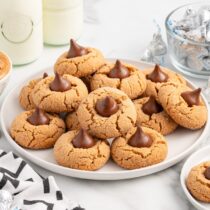 a couple of peanut butter kiss cookies on the plate.