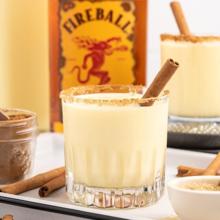 a glass of Fireball Eggnog with cinnamon stick.