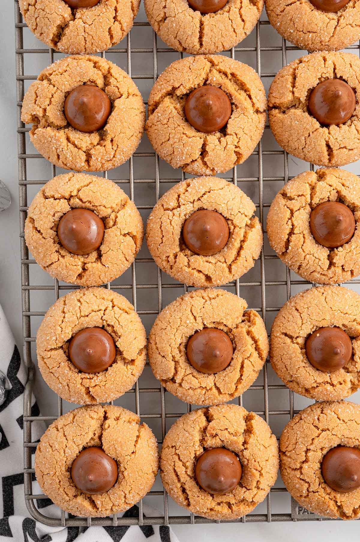 peanut butter kiss cookies on top of cooling rack. 