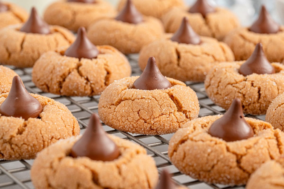 a couple of peanut butter kiss cookies on a cooling rack.