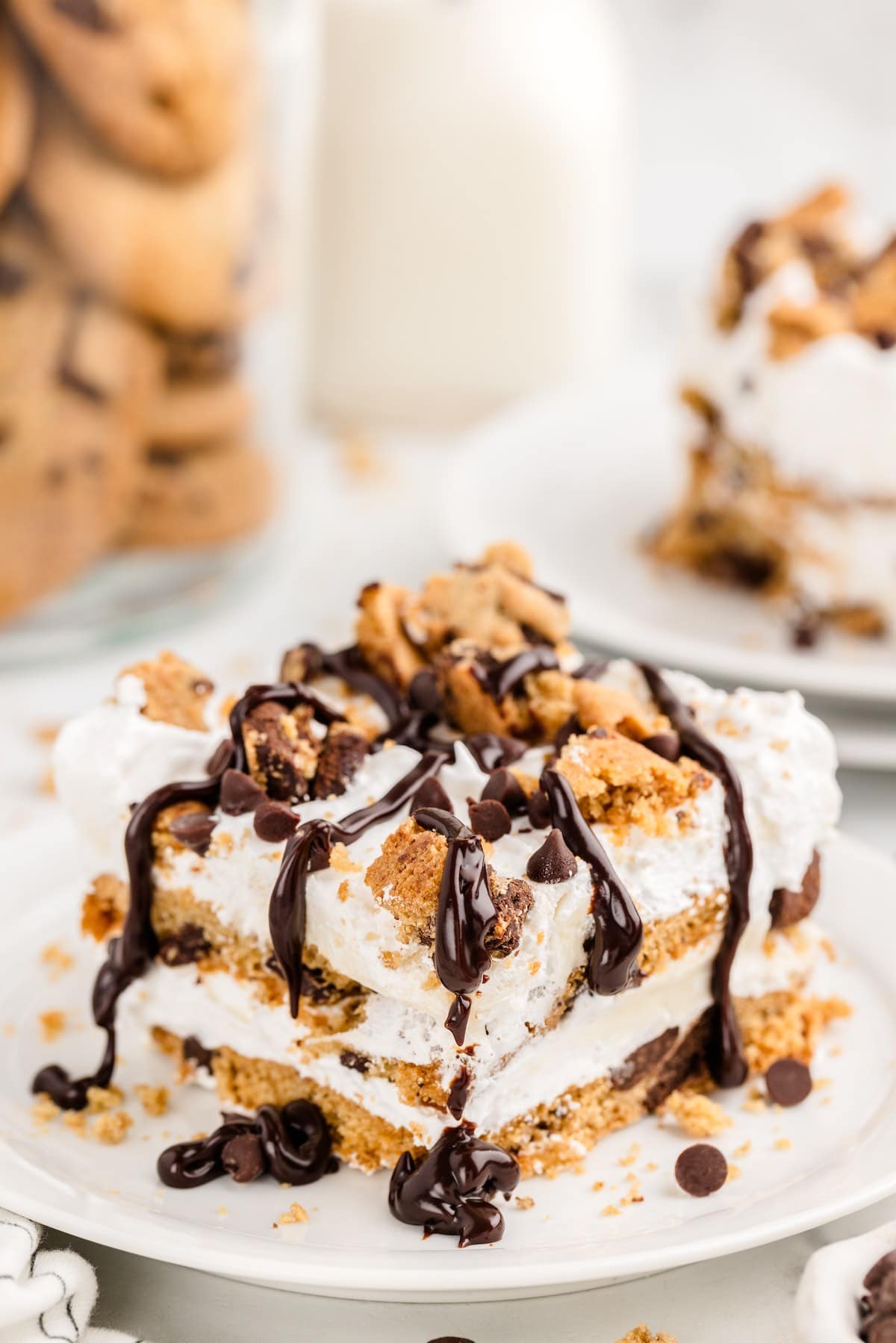 a slice of Cookie Lasagna  with cookie crumble on top and drizzled with chocolate sauce.