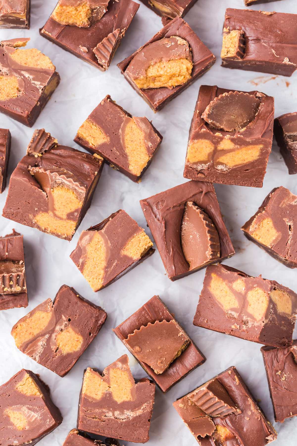 Easy Reeses Fudge cut into several small squares and scattered on the table.