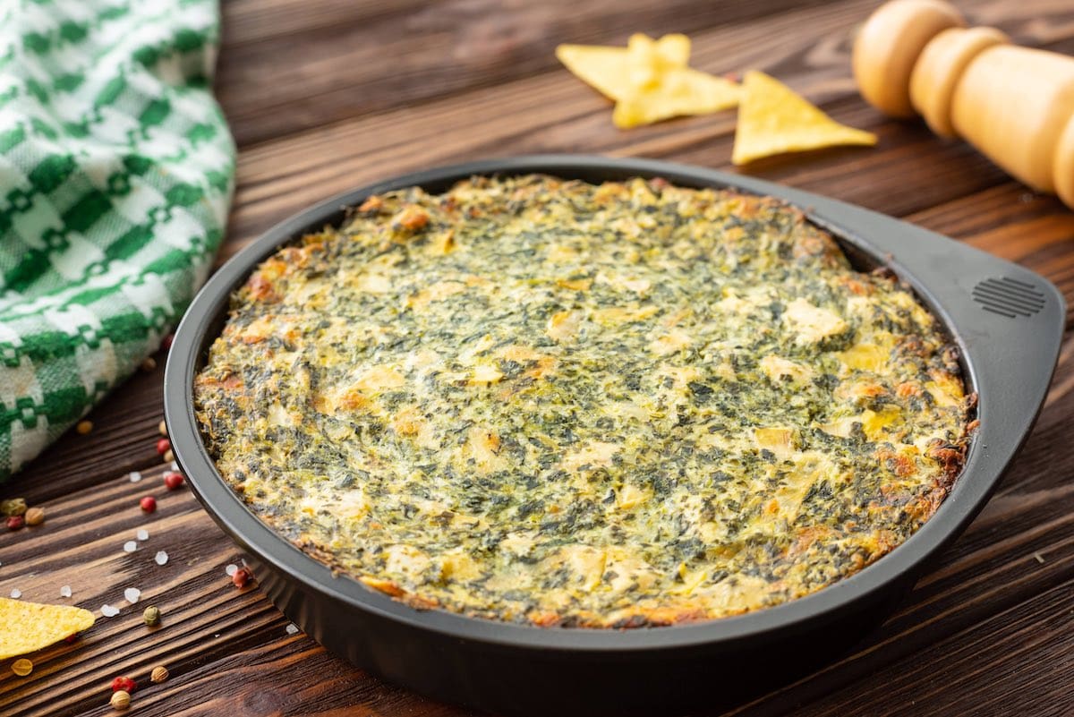 Spinach Artichoke Dip on top of wooden table
