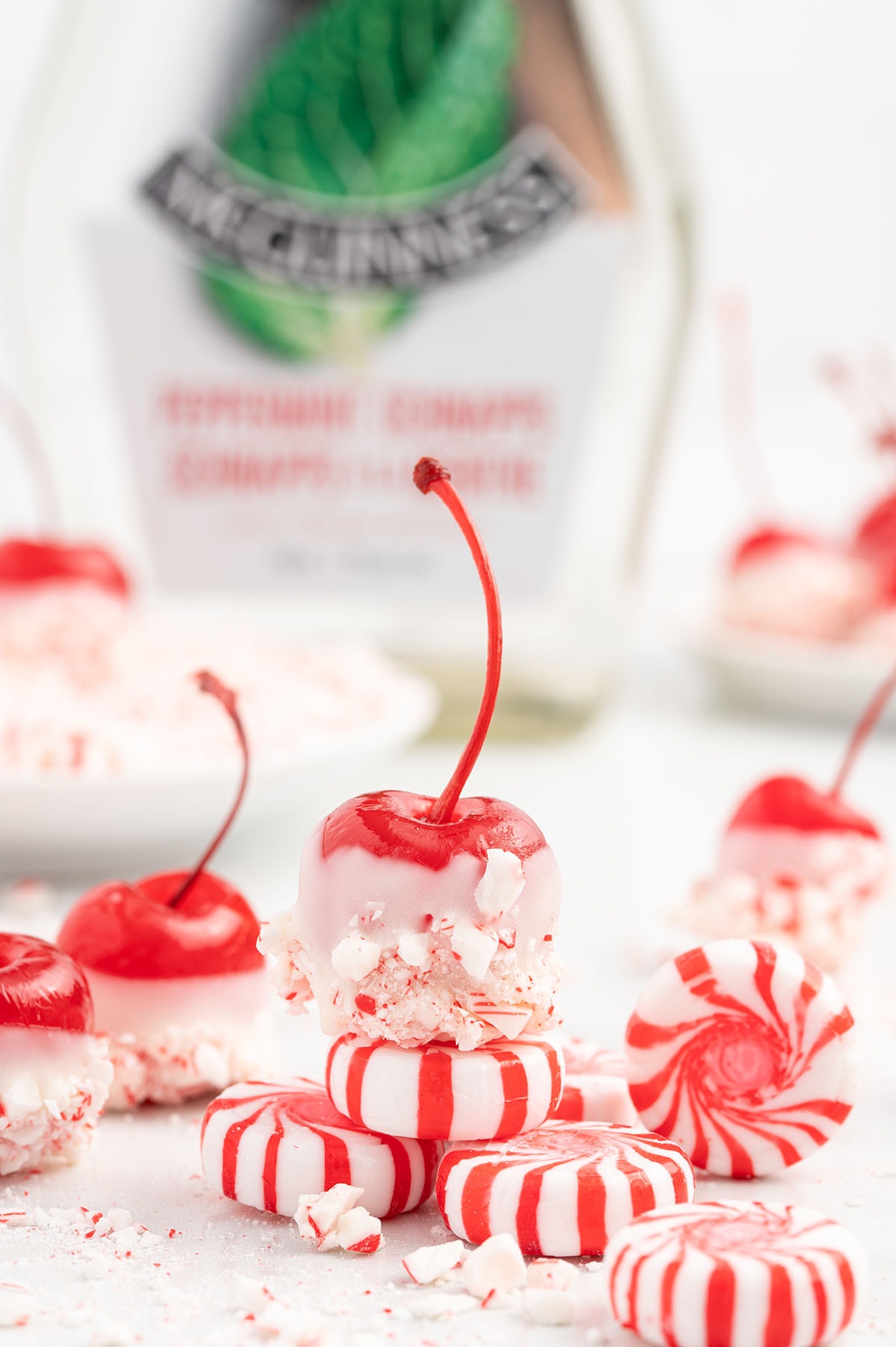 a couple of Christmas Cherry Bombs on the table stacked on top peppermint candy.