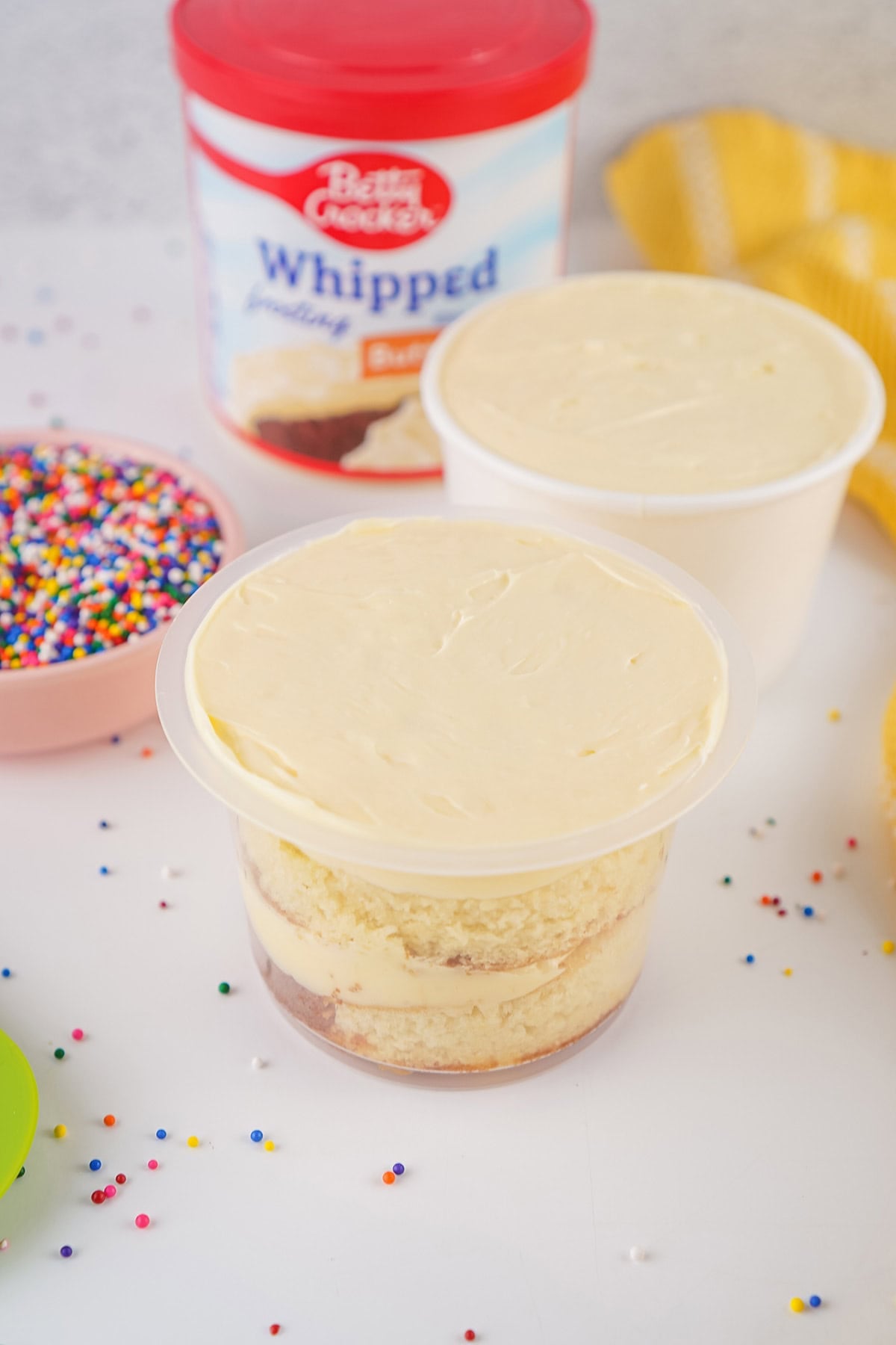 Layer cake cups filled with creamy frosting, ready for sprinkles.