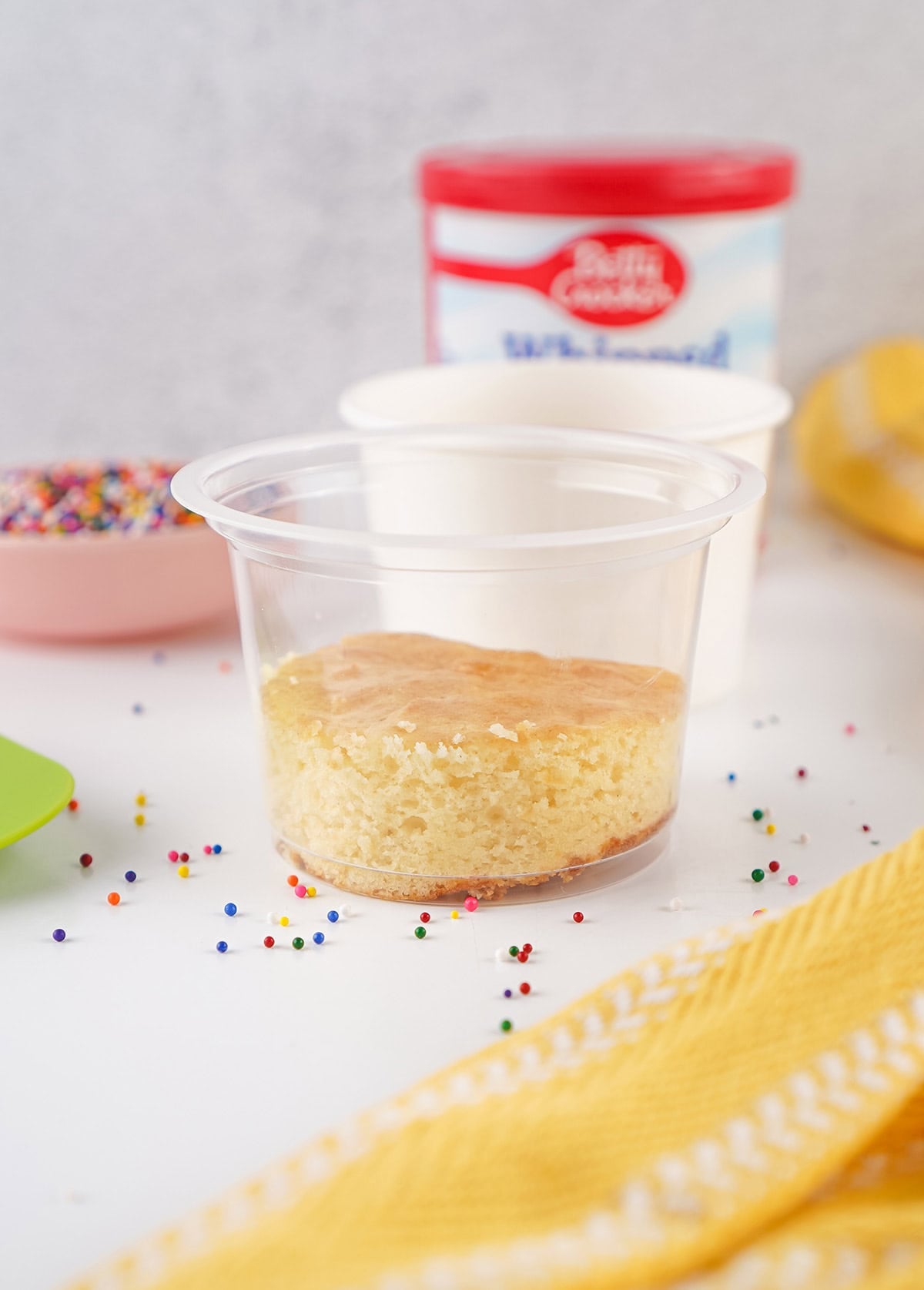 Single layer of vanilla cake placed inside a clear dessert cup.