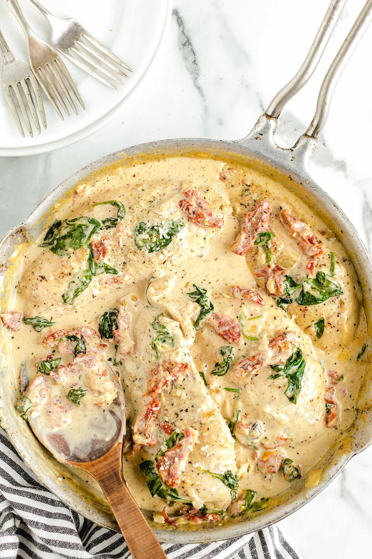 tuscan chicken with dried tomatoes and creamy sauce in a pan.