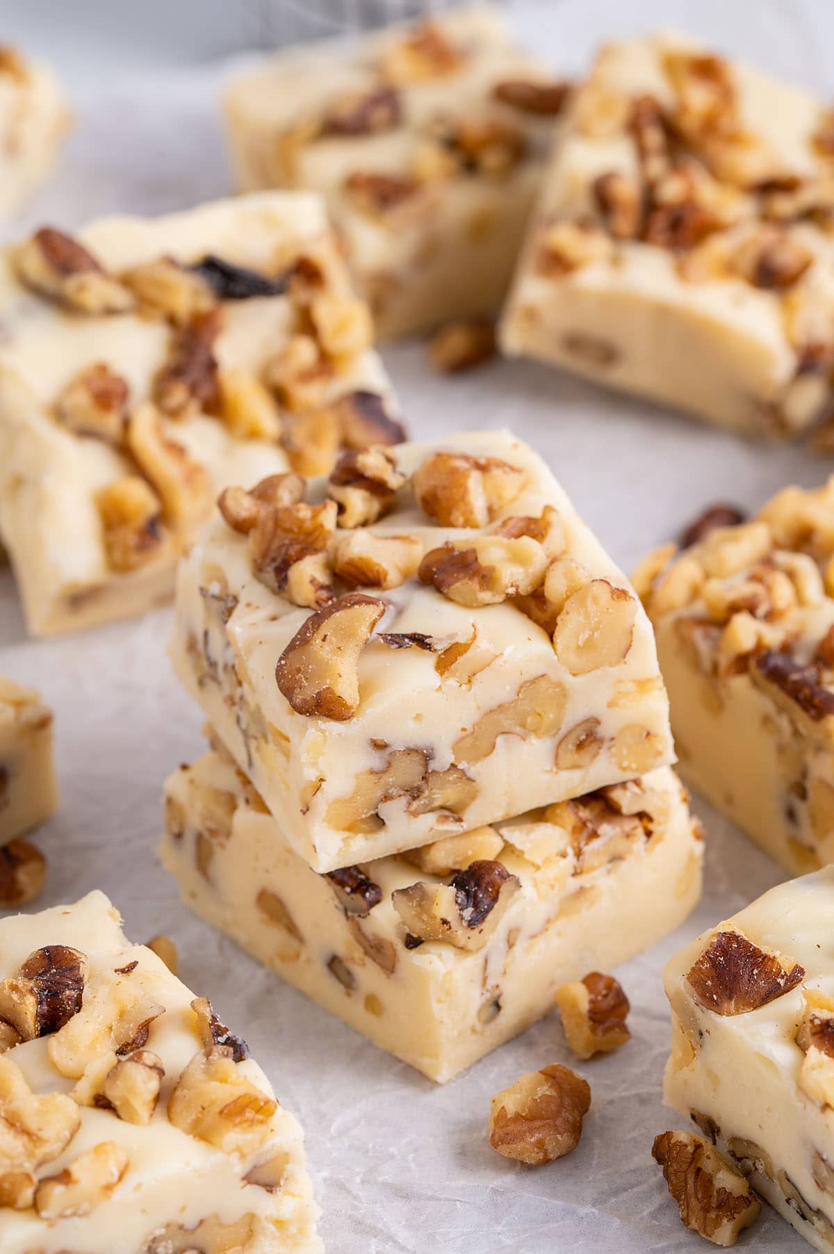 Maple Walnut Fudge stacked on top of parchment paper.