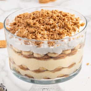 Nutter Butter Trifle in a glass trifle bowl with toppings.