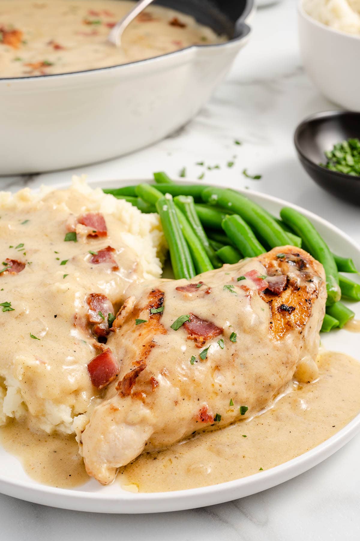 Smothered Chicken served with string beans and mashed potatoes.