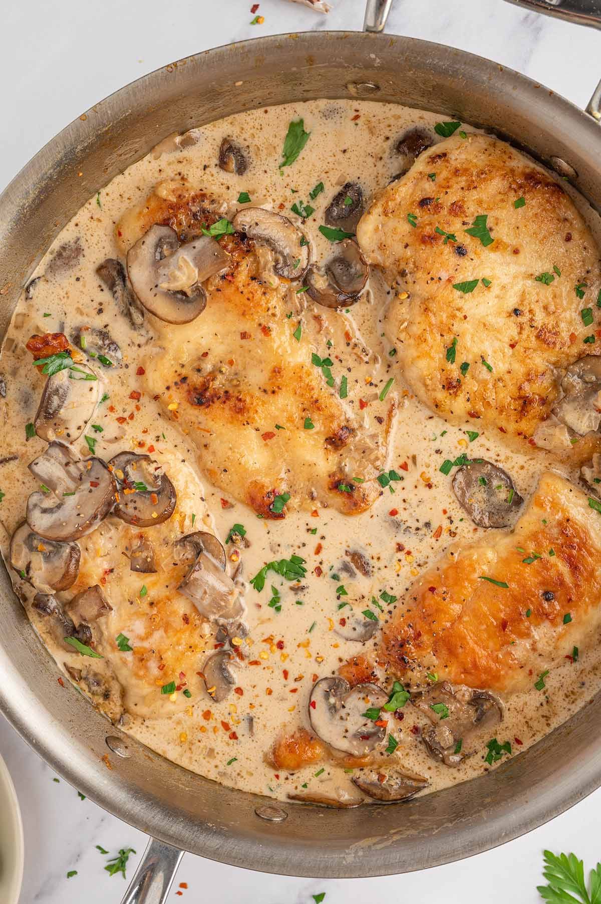 Easy Chicken Marsala in a large skillet sprinkled with chopped parshley.