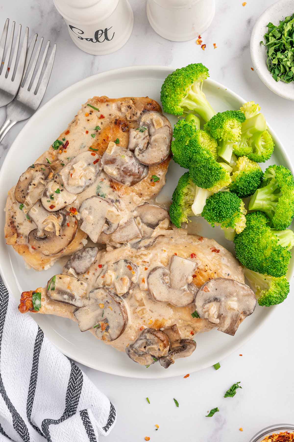 2 Chicken Marsala on a white plate with broccoli.