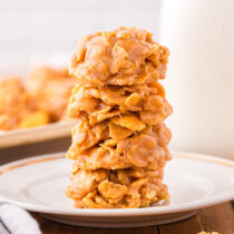 a couple of Peanut Butter Cornflake Cookies stacked on a plate.