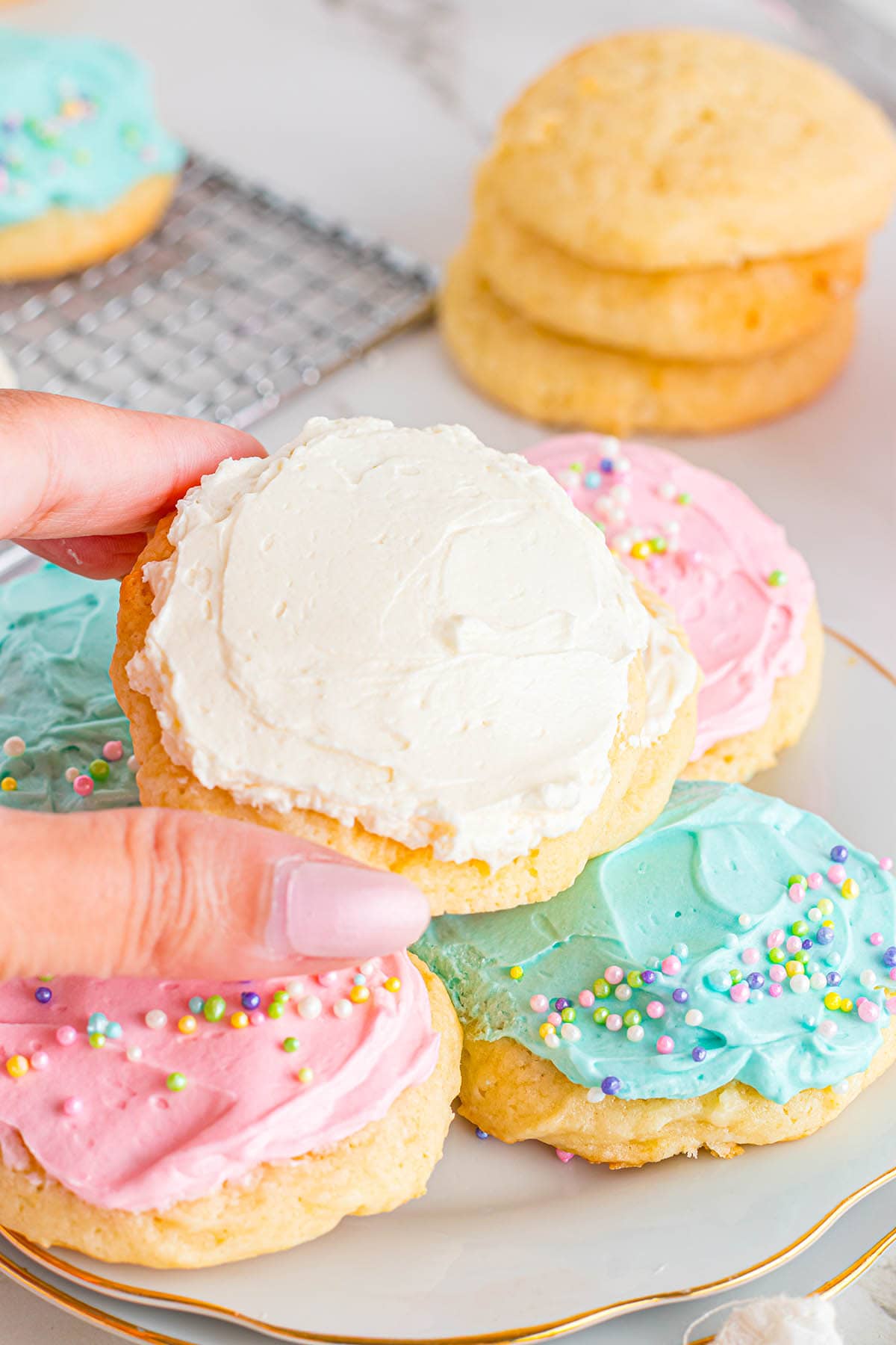 hand holding a Sour Cream Cookies with buttercream.
