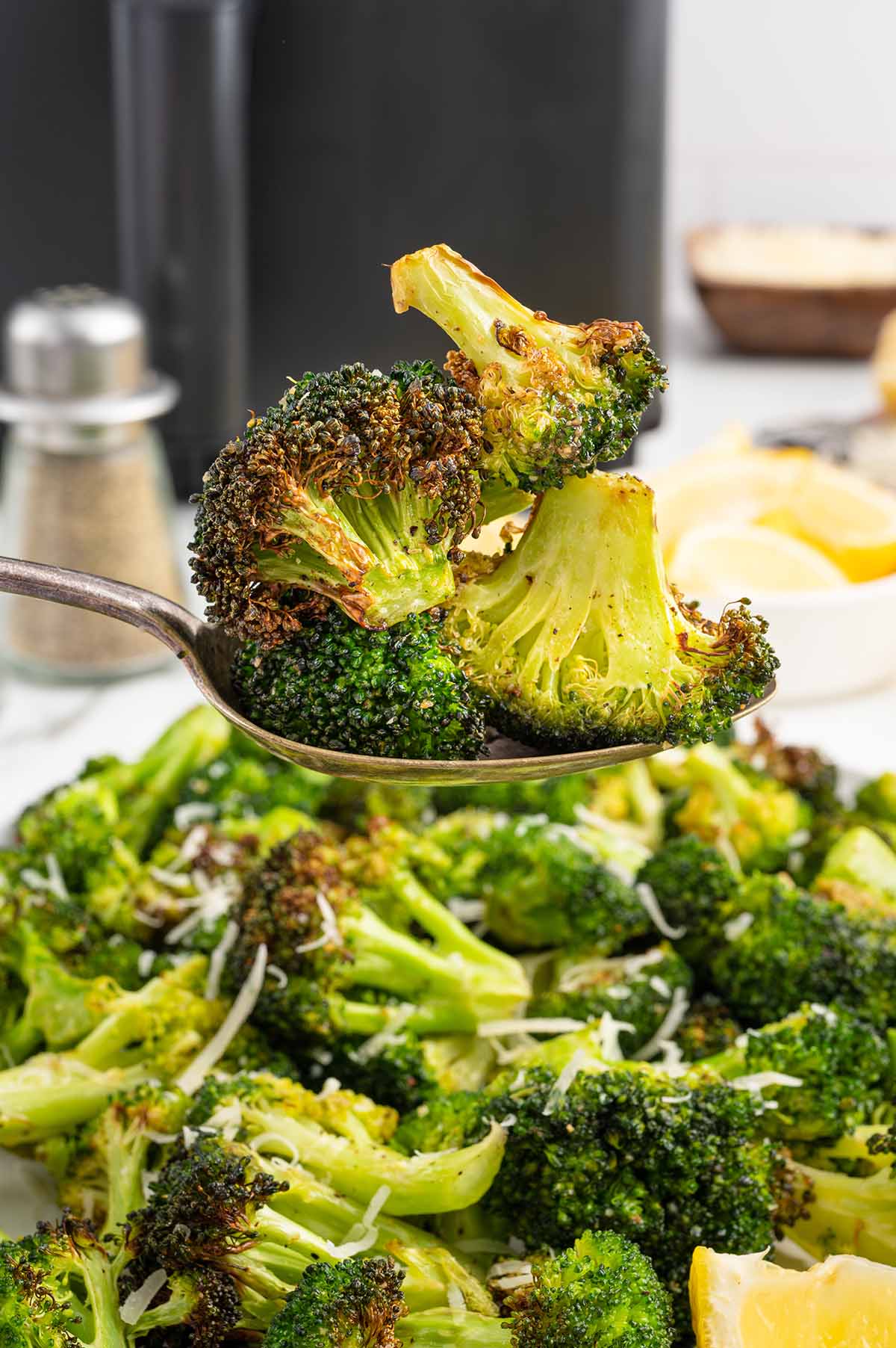 eating Air Fryer Broccoli using a spoon.