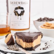 Skrewball Pie on a plate with a bottle of skrewball on the background.