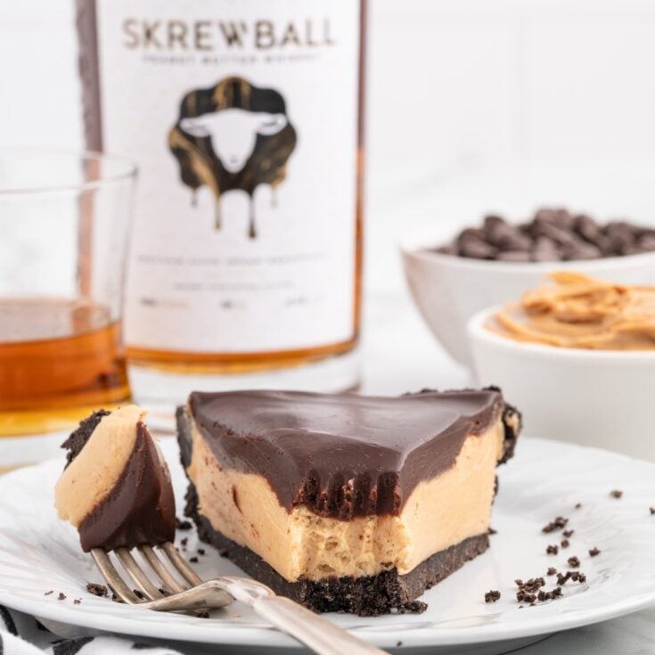 Skrewball Pie on a plate with a bottle of skrewball on the background.