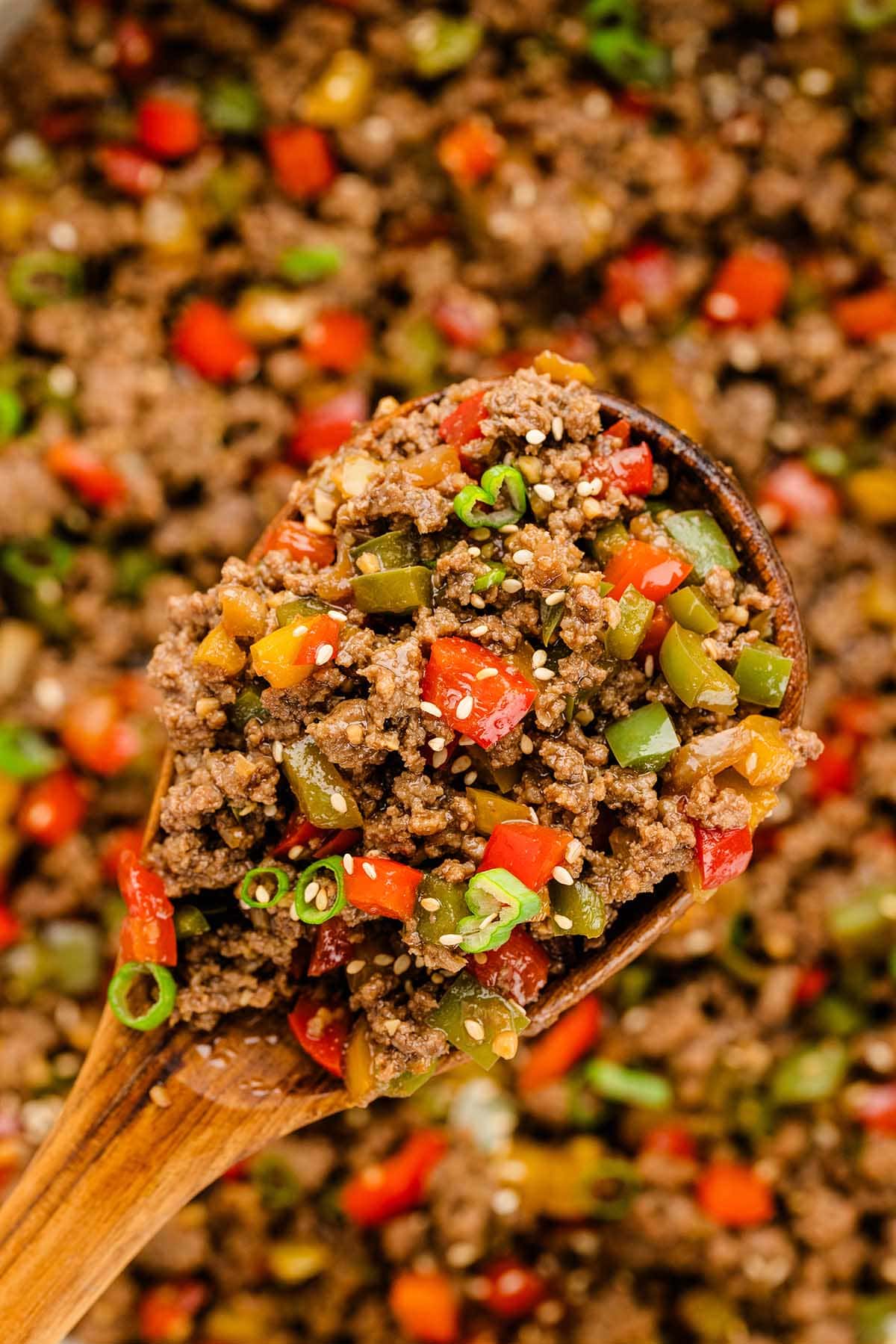 a spoonful of Beef and Pepper Rice Bowl using a wooden spoon.