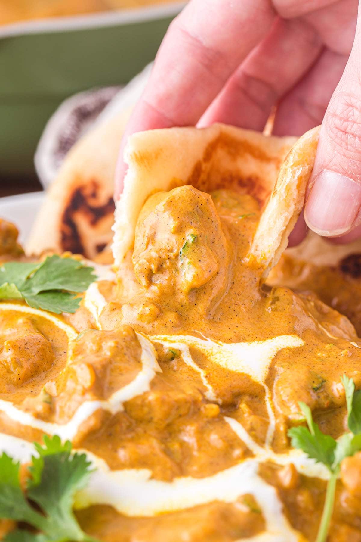 naan bread dipped into the Indian Butter Chicken.