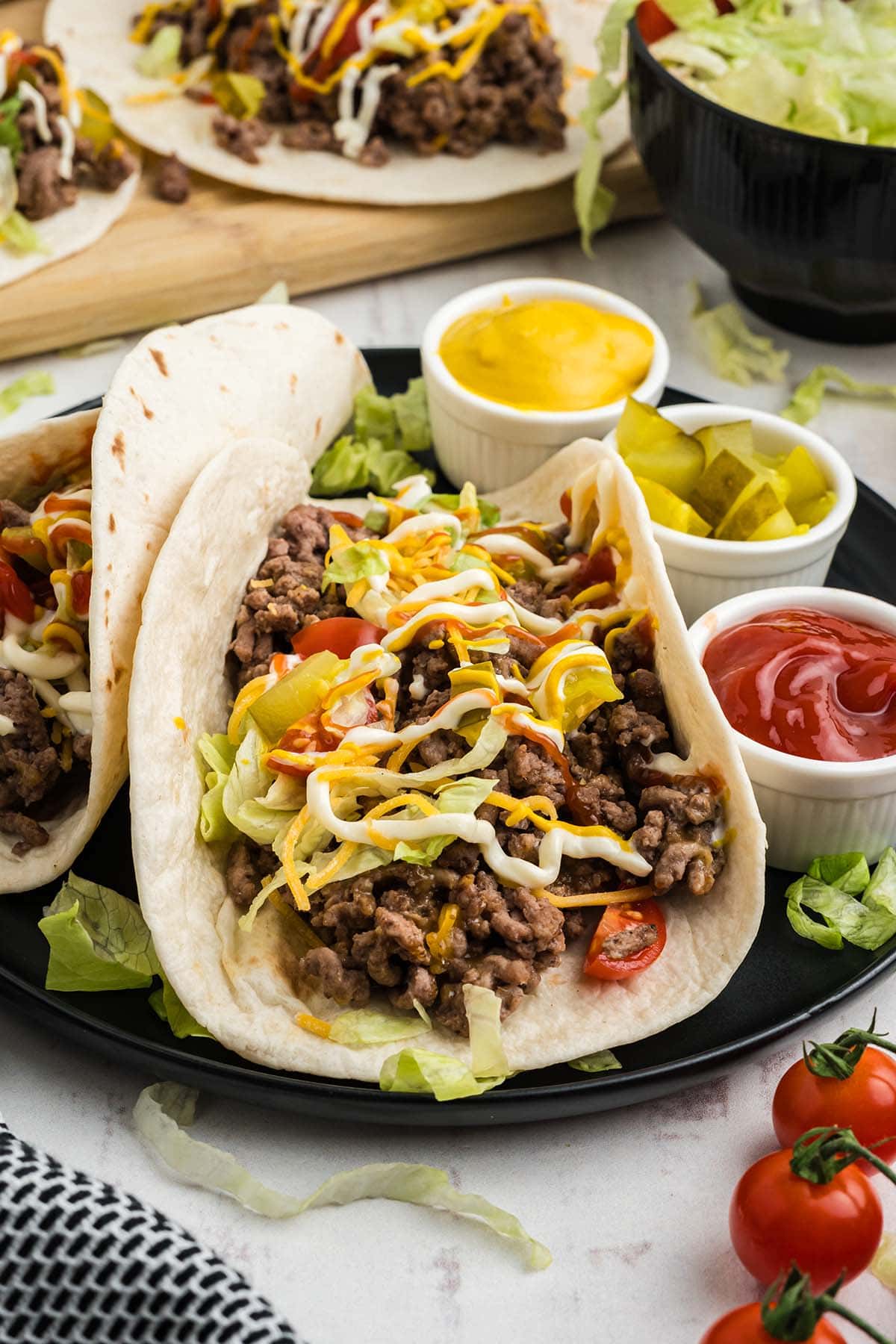 Cheeseburger Tacos drizzled with tomato sauce and mustard.