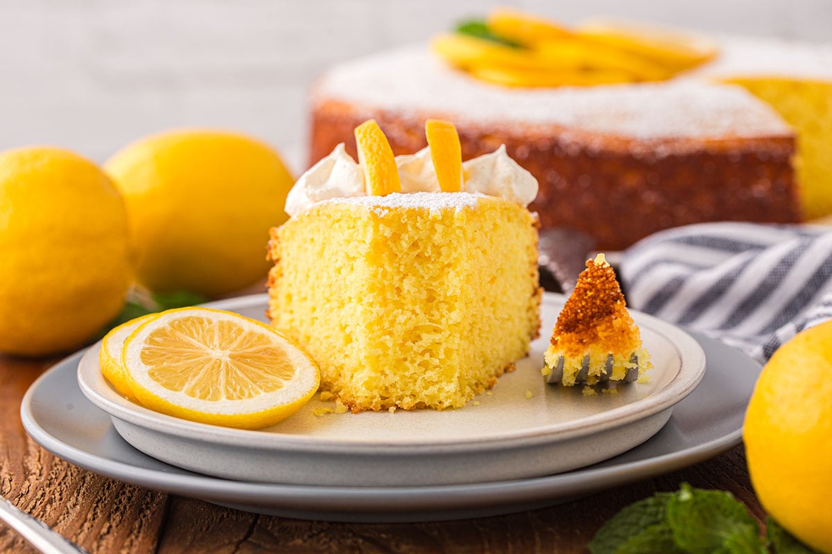 lemon ricotta cake with a couple of lemons on the background.