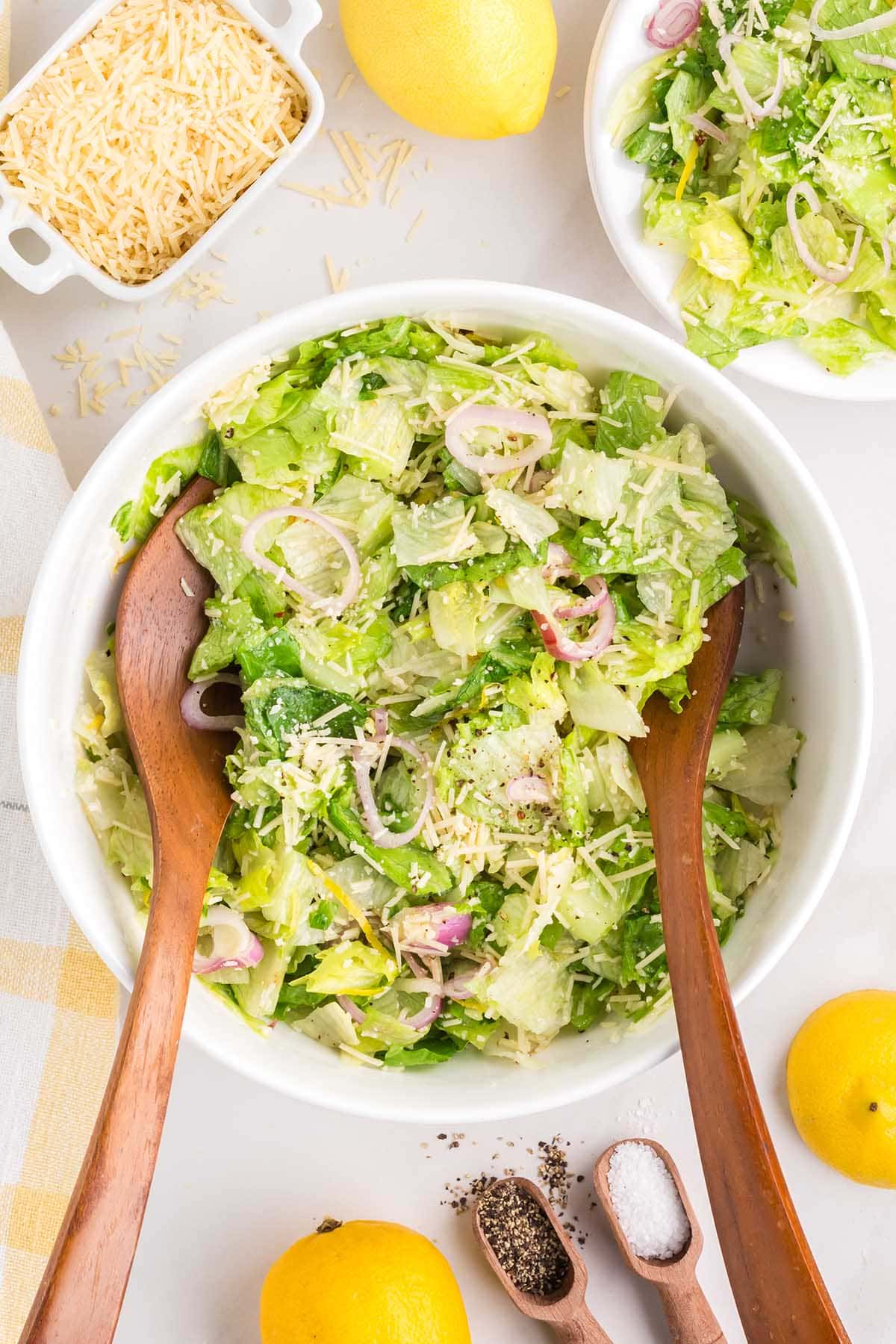 Lemon Parmesan Salad in a white bowl with 2 wooden spoon.