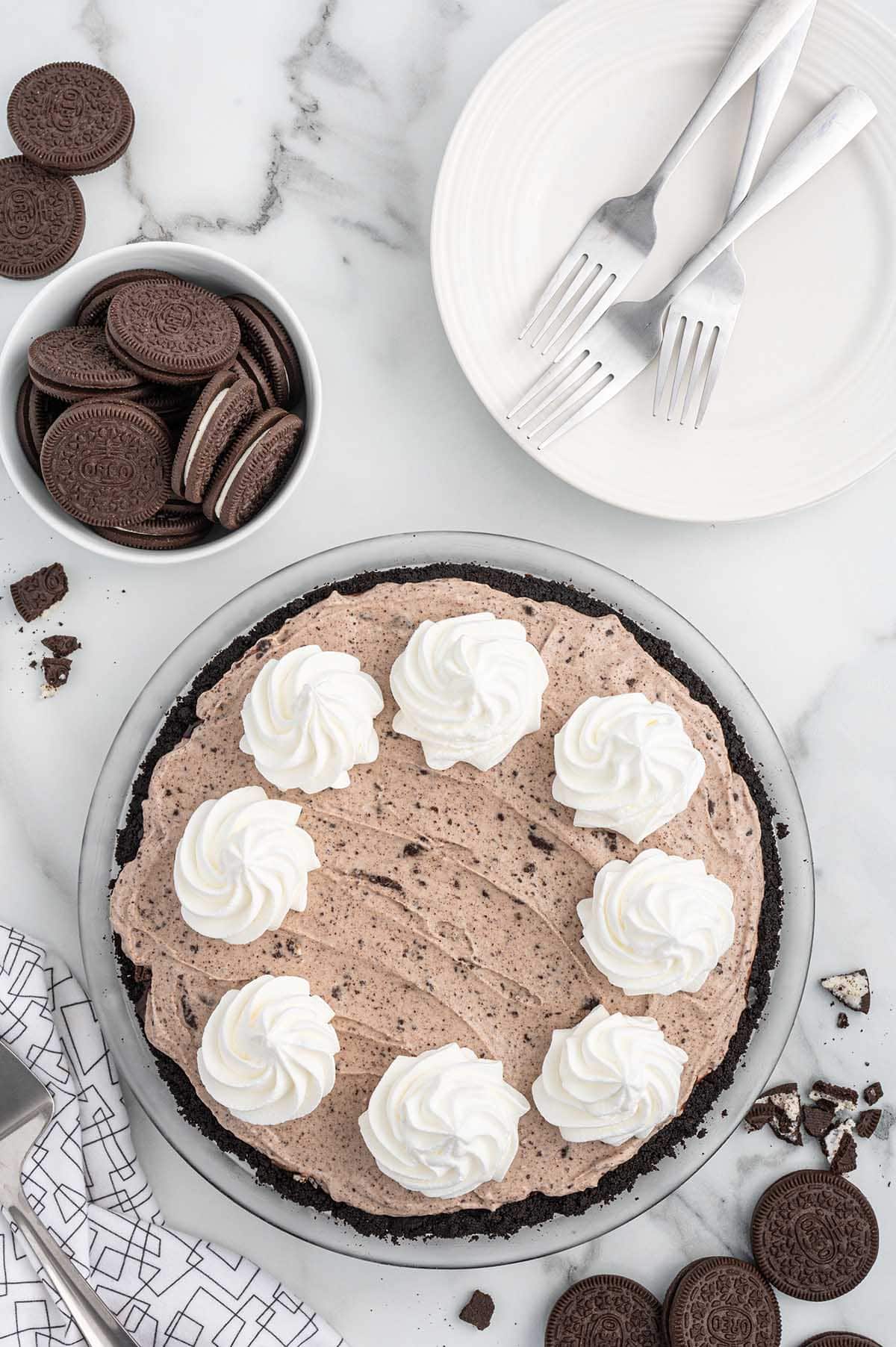Ice Cream Pie on the table with a couple of oreo cookies on the background.