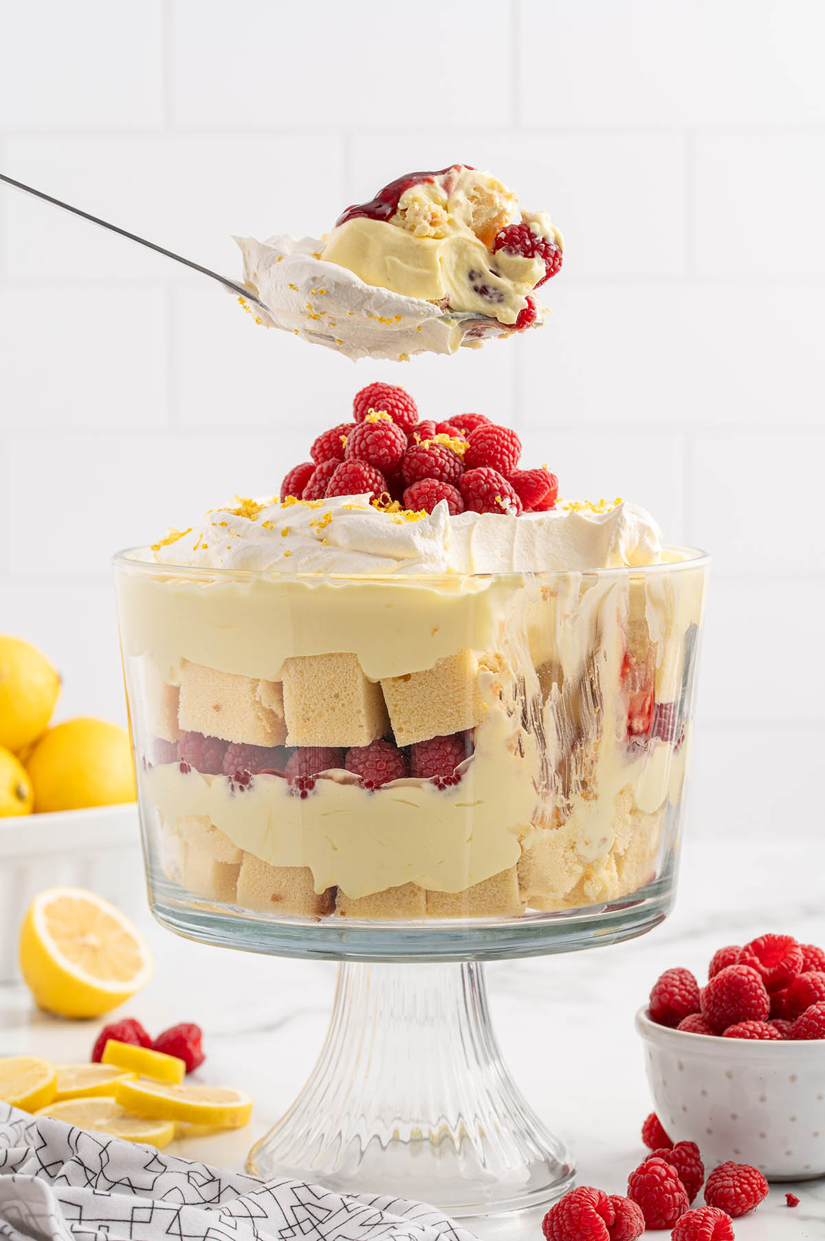 taking a spoonful of lemon raspberry trifle from the trifle bowl.