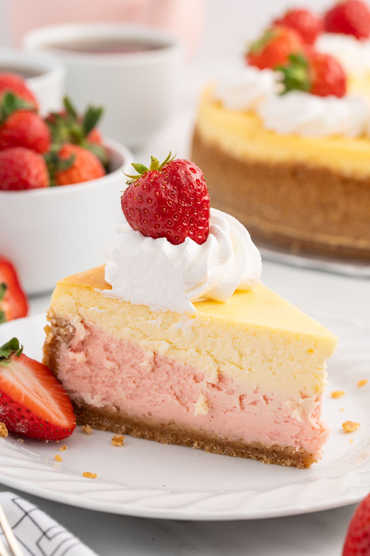 a slice of Strawberries and Cream Cheesecake on the plate.