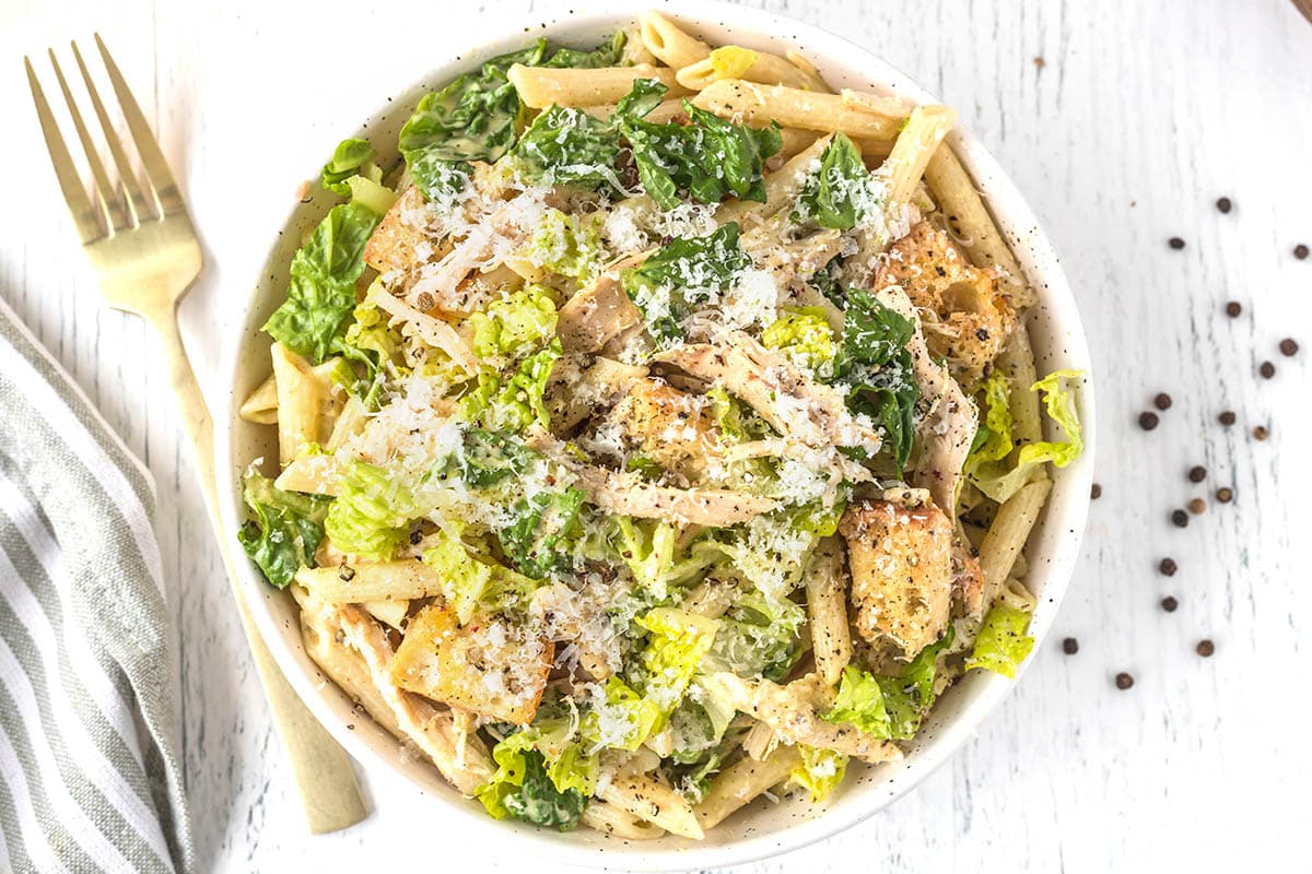 Chicken Caesar Pasta Salad in a large bowl with a fork on the side. 